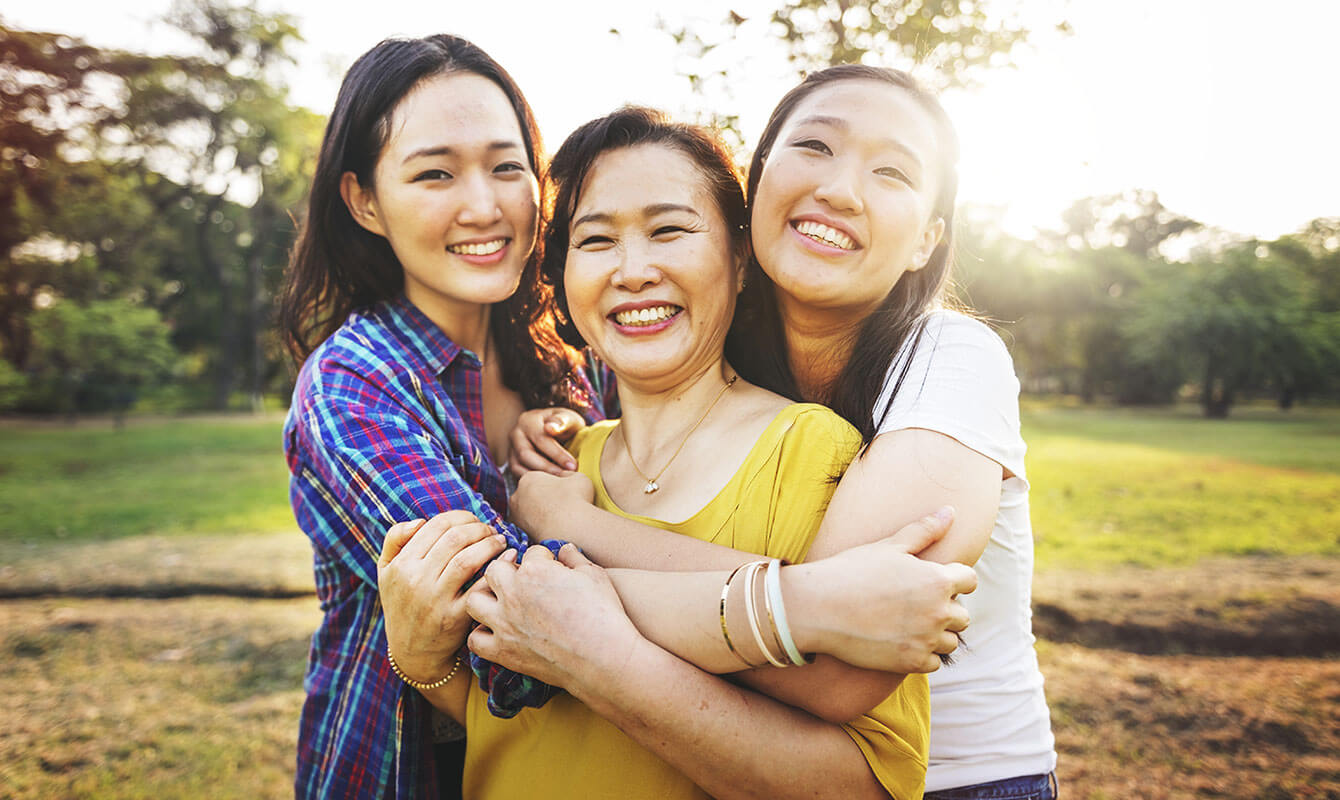 2 young women hugging their mother