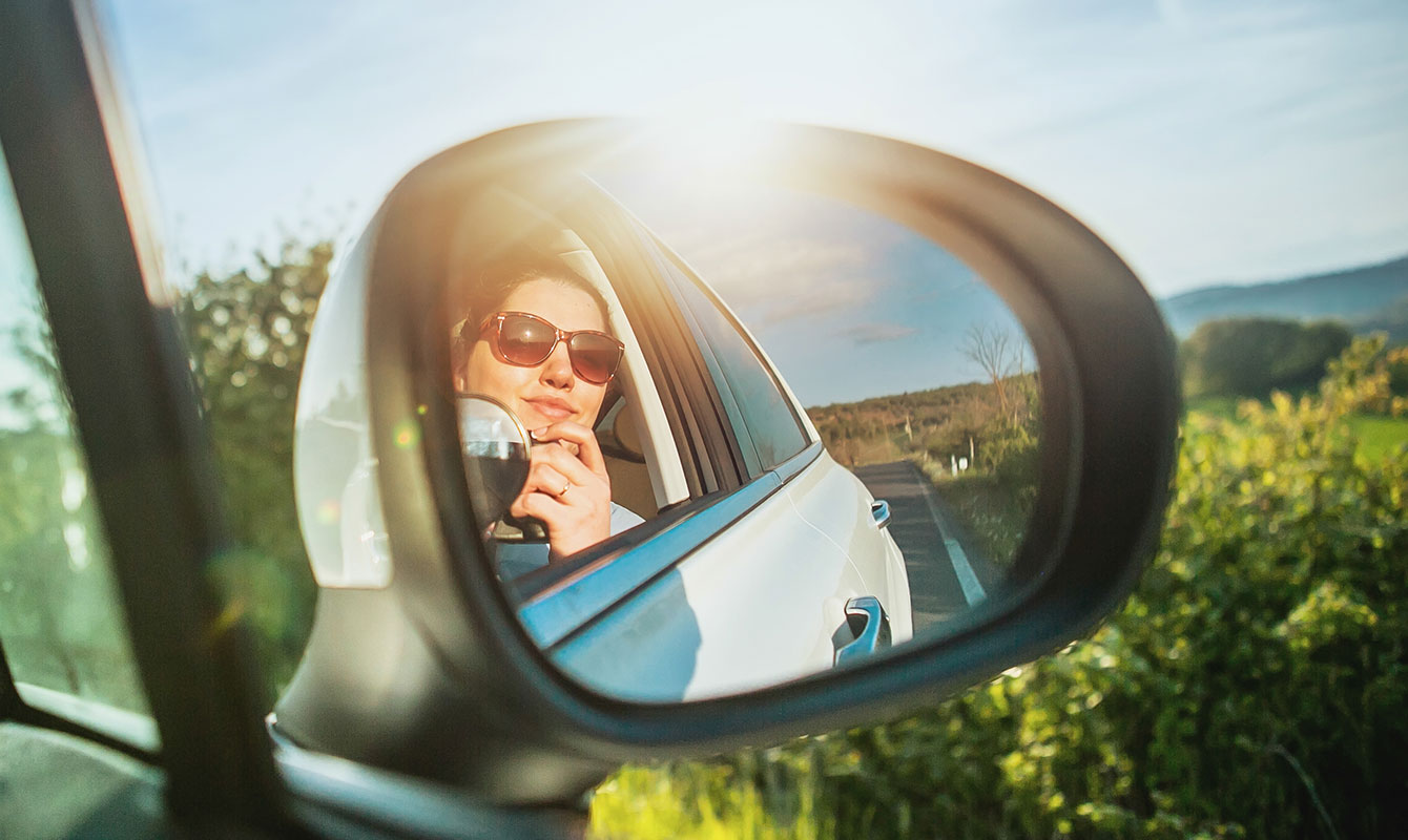 Miroir de voiture reflétant le visage d'une jeune femme